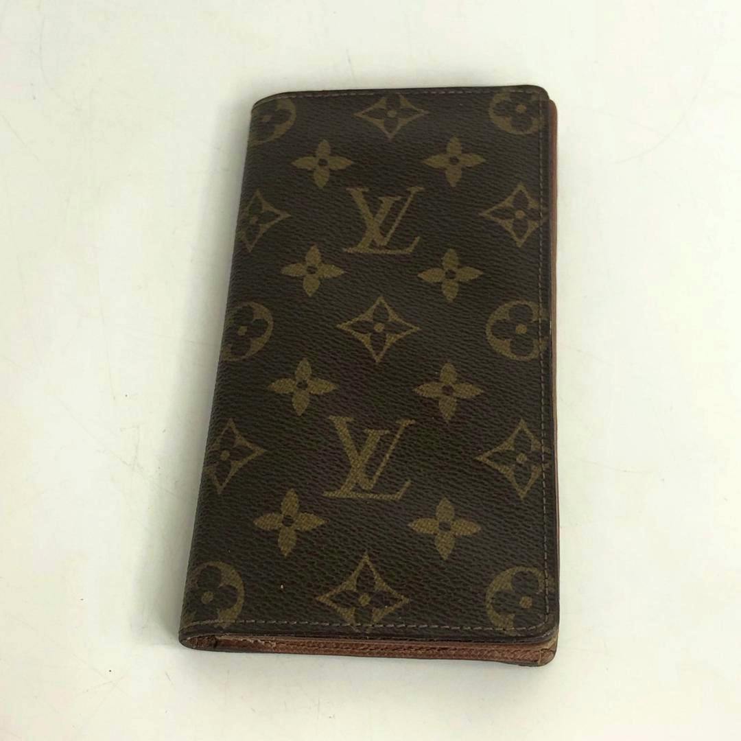 Closed Louis Vuitton monogram canvas long wallet shown on a white surface.
