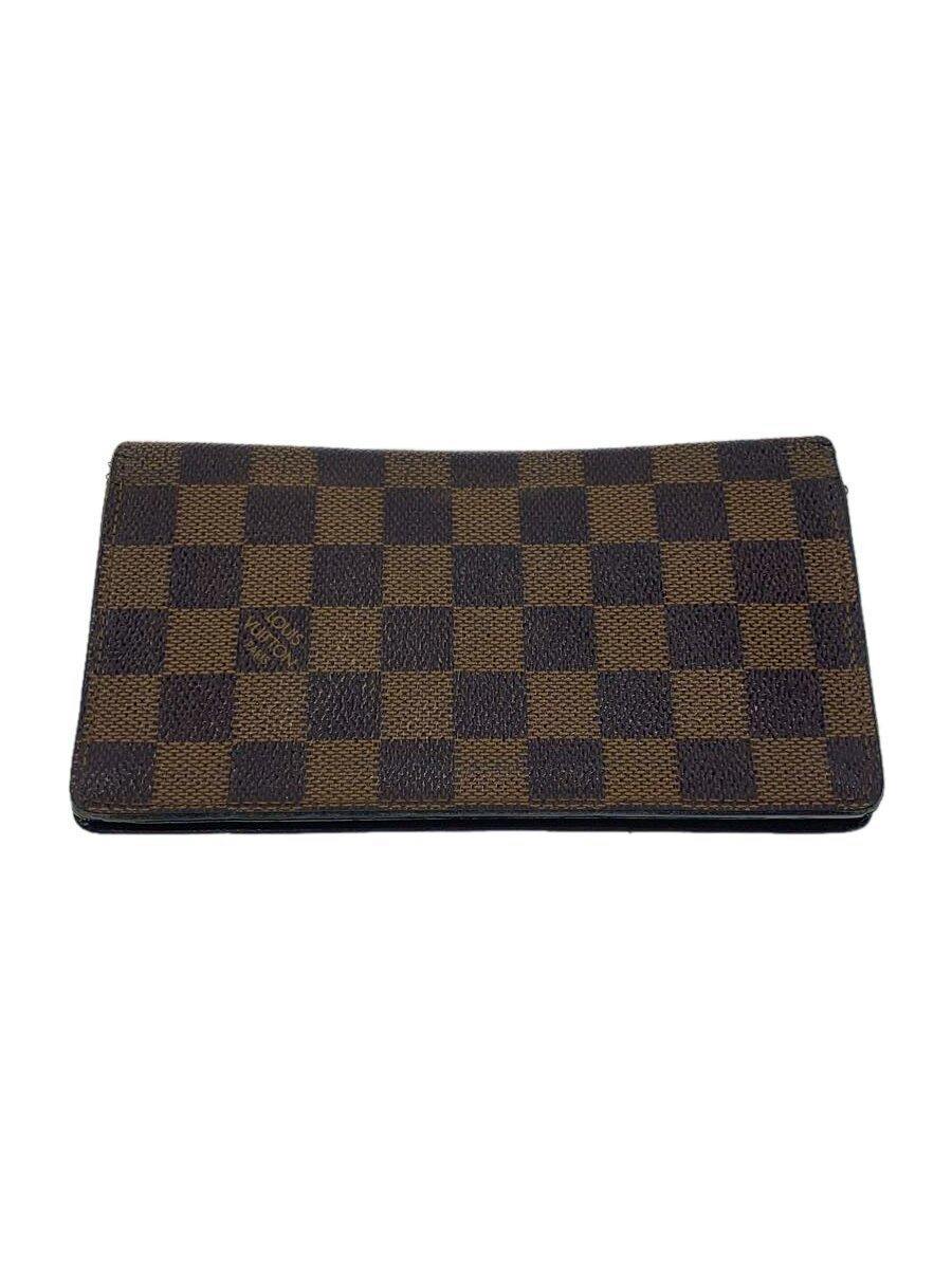 Brown Louis Vuitton Damier Ébène patterned wallet shown flat on a white background, exterior checkerboard visible.