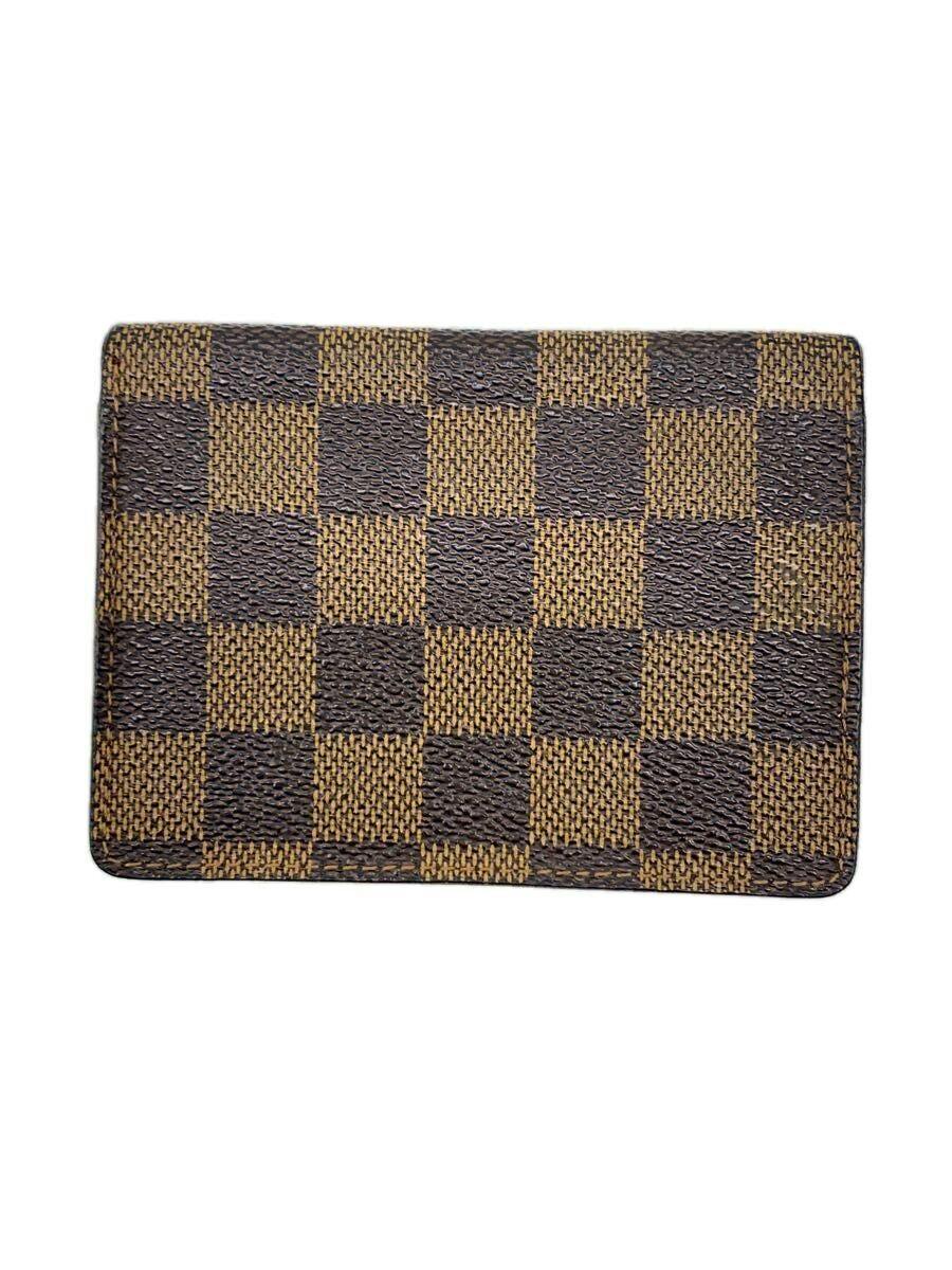Brown Louis Vuitton Damier Ebene checkered exterior of a vertical card holder wallet.