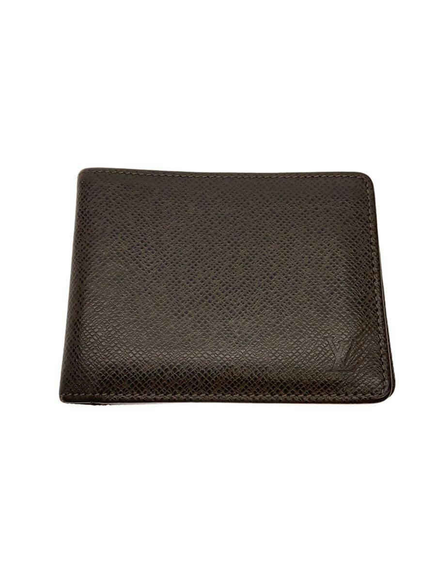 Closed brown cow-leather Louis Vuitton wallet shown on a white background with the embossed LV logo visible at the lower right.