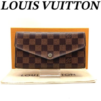 Front view of the Louis Vuitton Portefeuille Sarah bifold long wallet in canvas displayed with box and pouch.