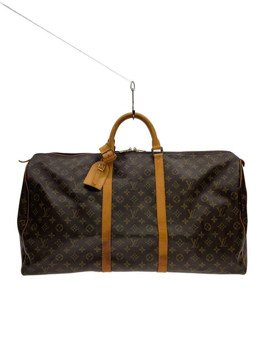 Front view of a Louis Vuitton monogram canvas duffle bag with brown leather handles and straps hanging from a hook.
