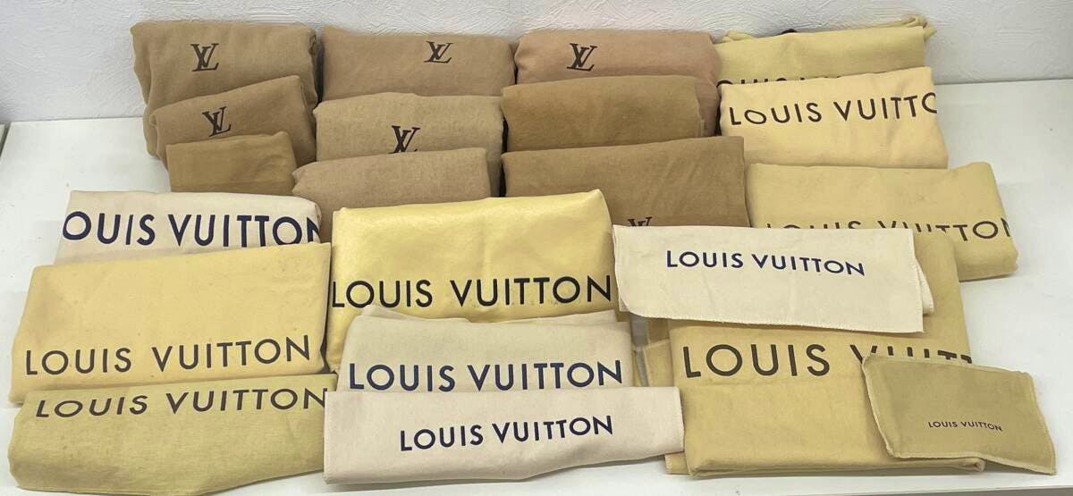 Multiple Louis Vuitton dust bags and pouches arranged on a flat surface.