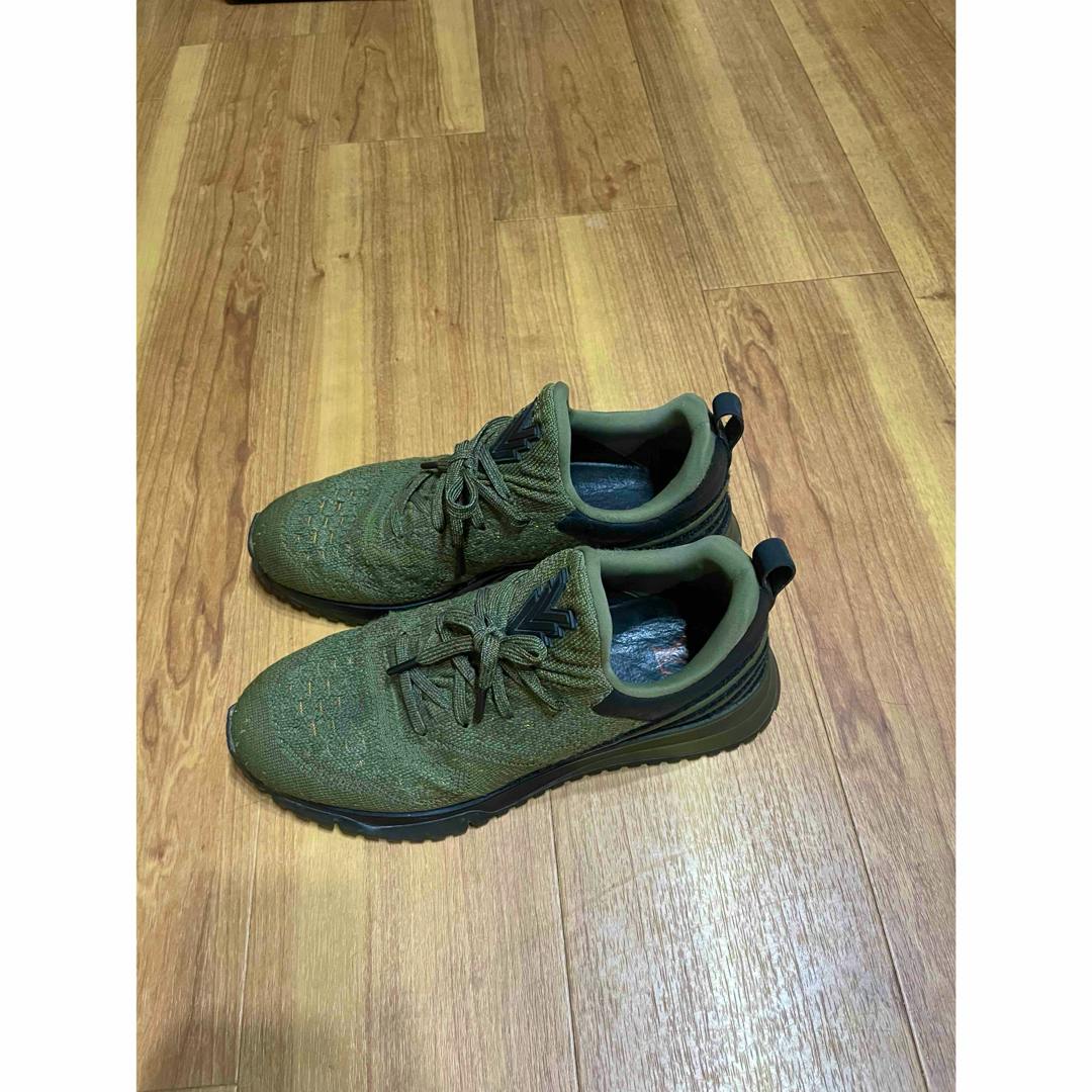 Green synthetic leather Louis Vuitton sneakers shown as a pair on a wooden floor.