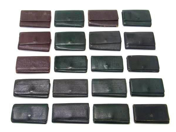 Multiple Louis Vuitton Taiga key cases (small wallets) arranged in rows on a white background.