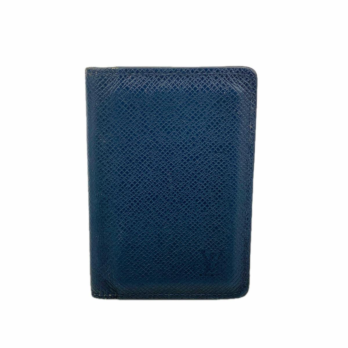 Blue LOUIS VUITTON Taiga leather card case shown closed on a white background.