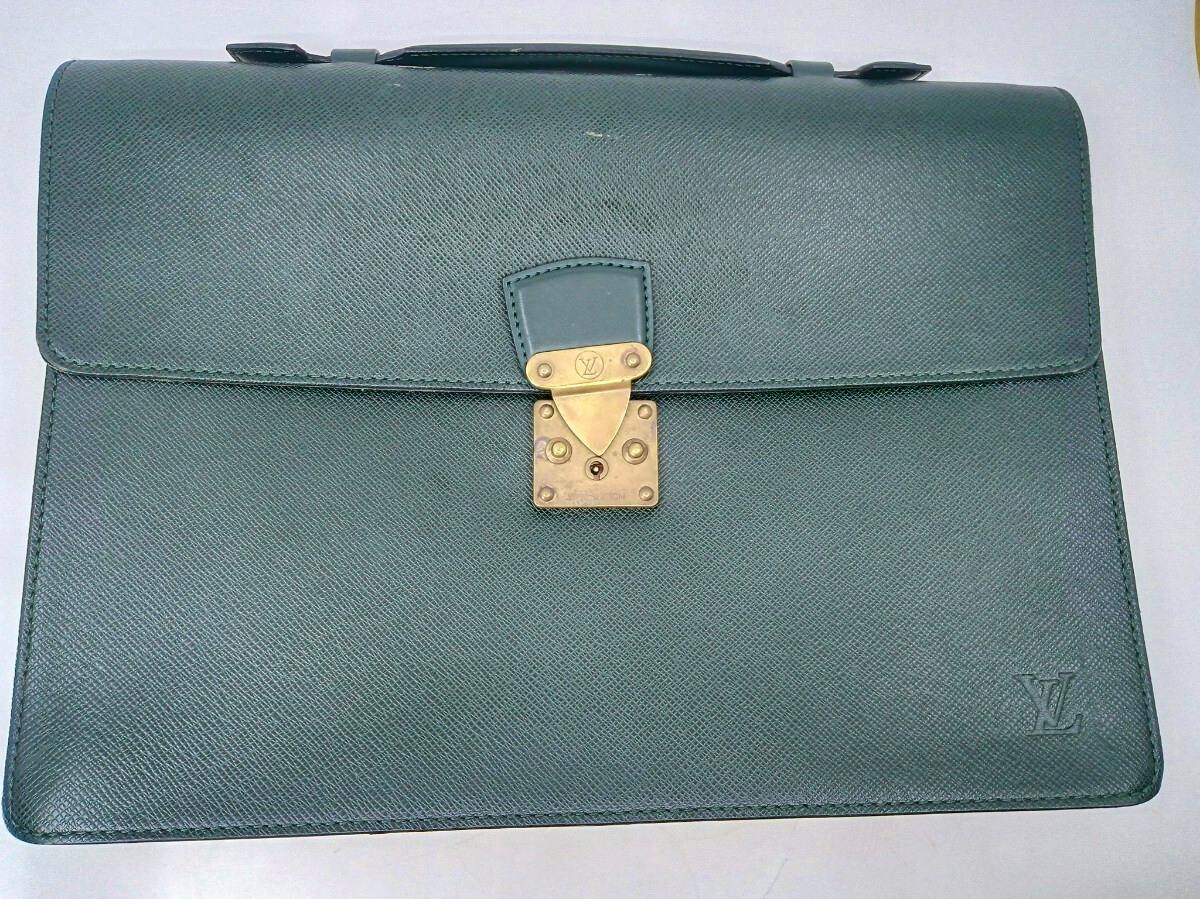 Front view of the LOUIS VUITTON Epicea cow leather business bag showing the flap, metal clasp with LV logo, and embossed LV on the lower corner.