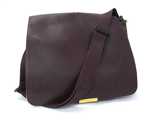 Dark brown Louis Vuitton M30146 Taiga Victor crossbody messenger shoulder bag with shoulder strap on a white background.