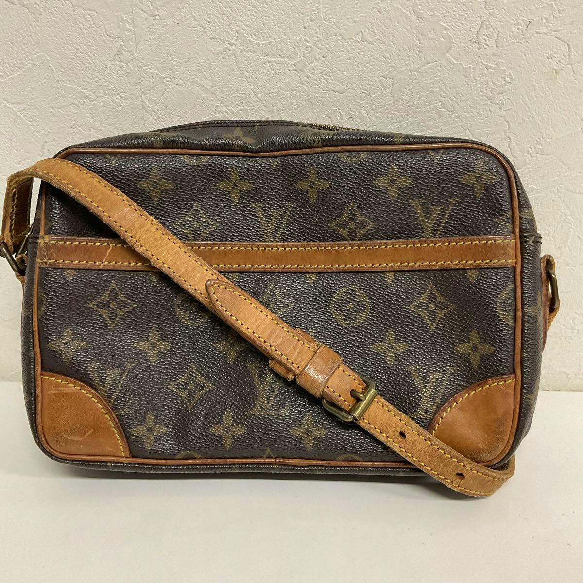 Front view of a LOUIS VUITTON monogram shoulder bag with tan leather trim and an adjustable leather strap on a plain background.