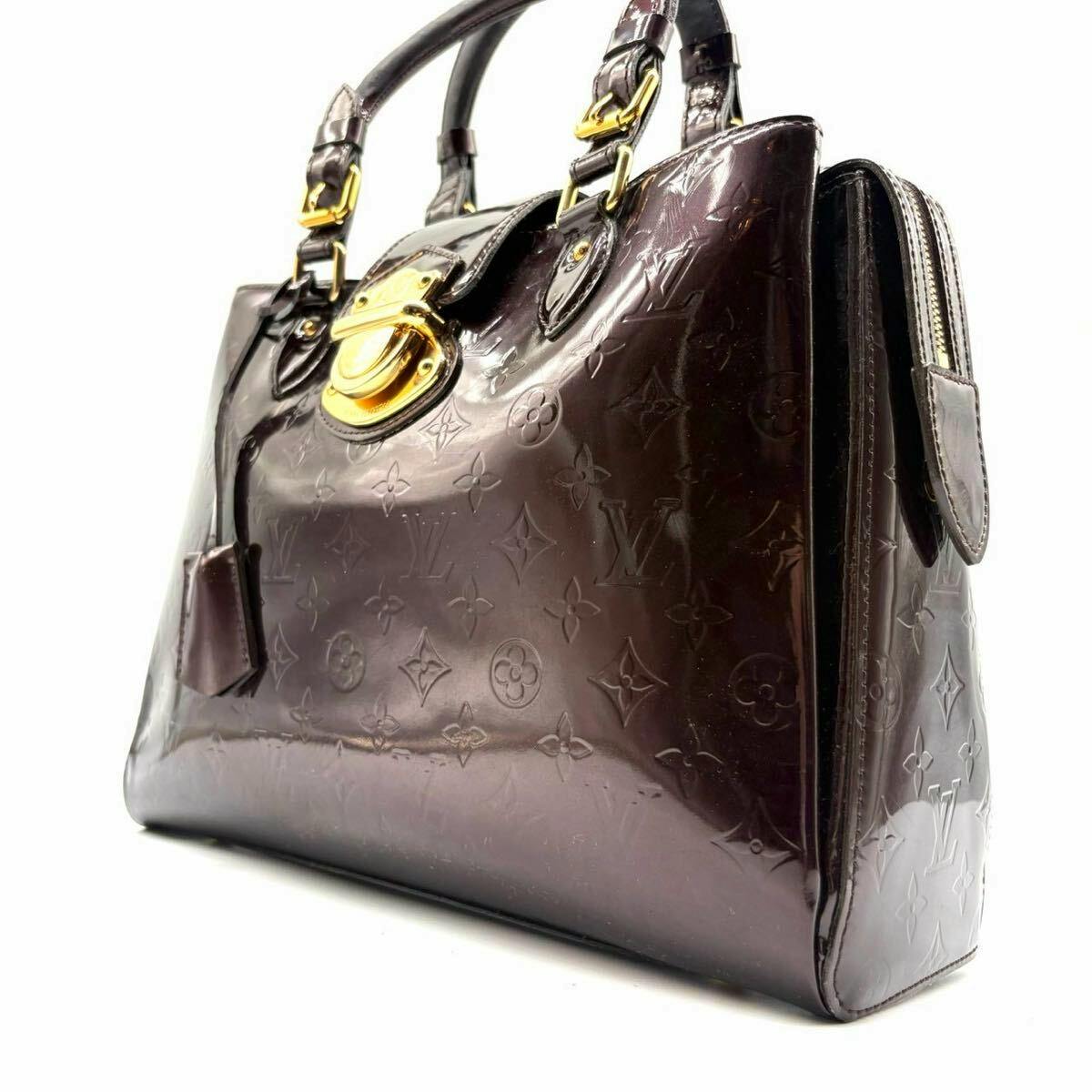 Wine-red Louis Vuitton Vernis patent tote bag with embossed monogram and gold hardware shown at an angled front-side view.