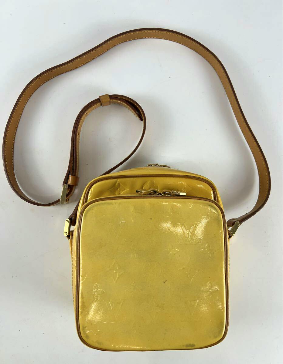 Yellow LOUIS VUITTON Vernis Wooster M91075 shoulder bag shown flat with its brown leather strap on a white background.