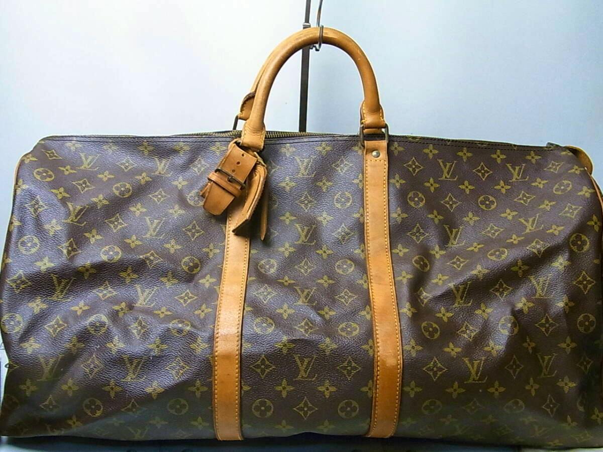 Front view of a Louis Vuitton monogram canvas Boston (ECLAIR) bag with leather handles and vertical leather straps.