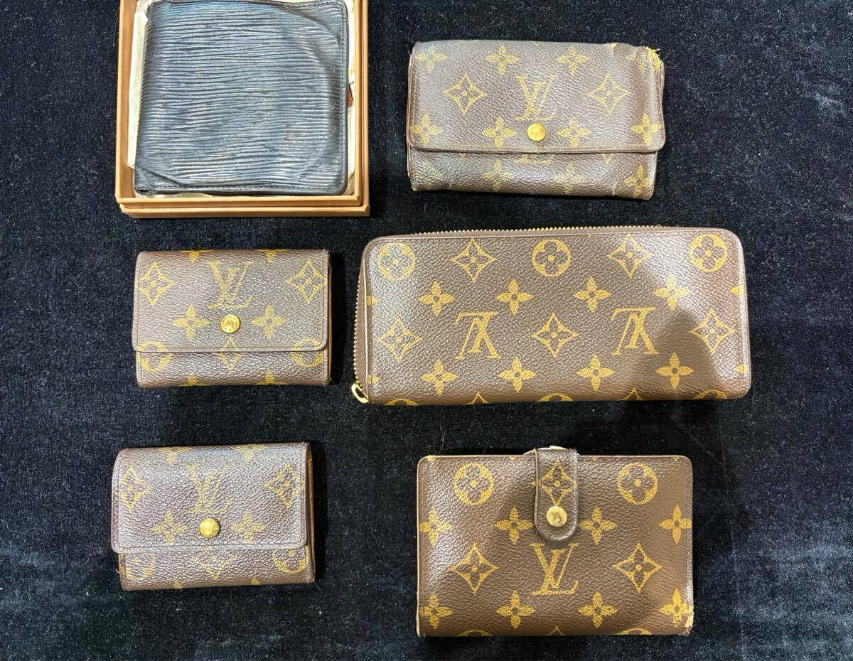 Several Louis Vuitton monogram and Epi wallets and coin cases arranged on a black background.
