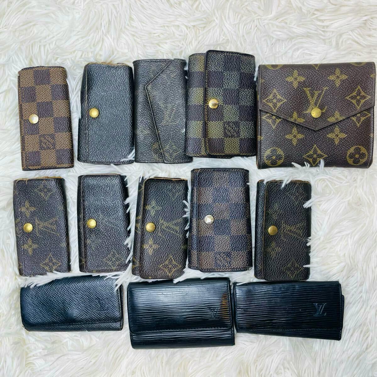A set of Louis Vuitton wallets and key cases (13 pieces) in monogram, Damier, and Epi patterns displayed on a white fur background.