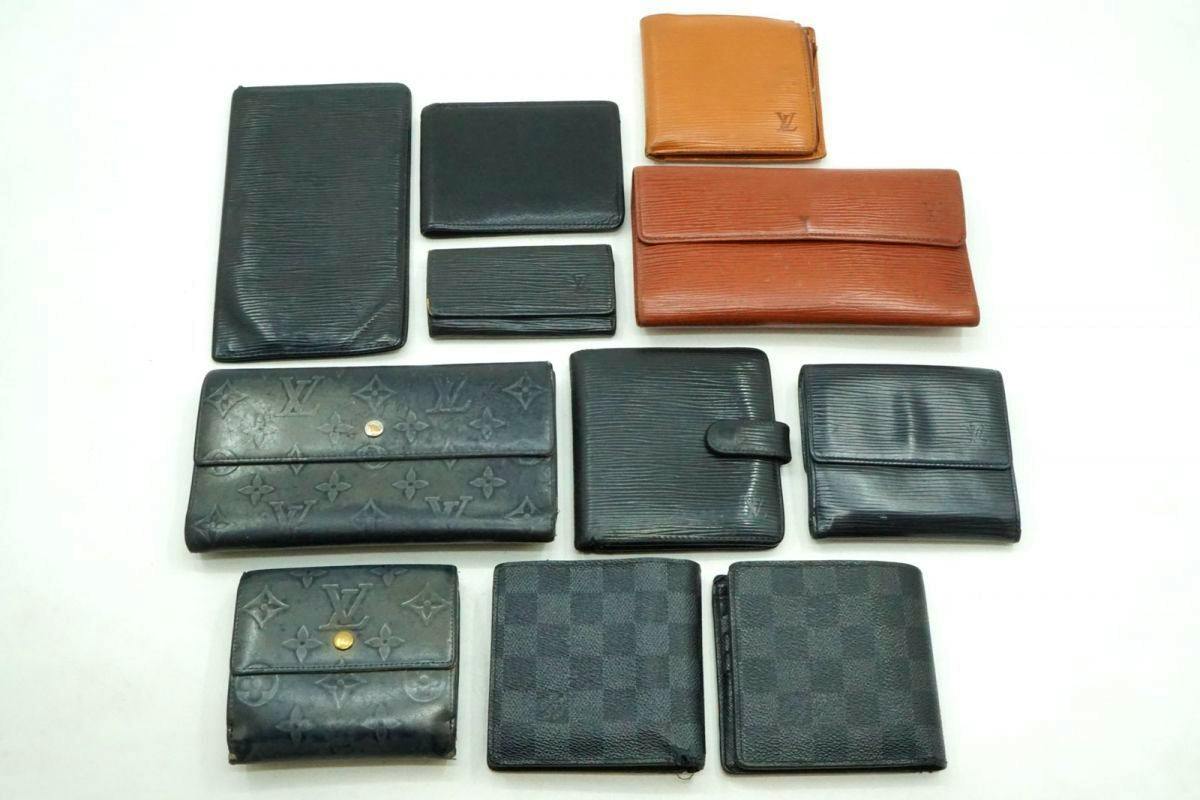 Eleven Louis Vuitton wallets and small leather goods arranged on a white background.
