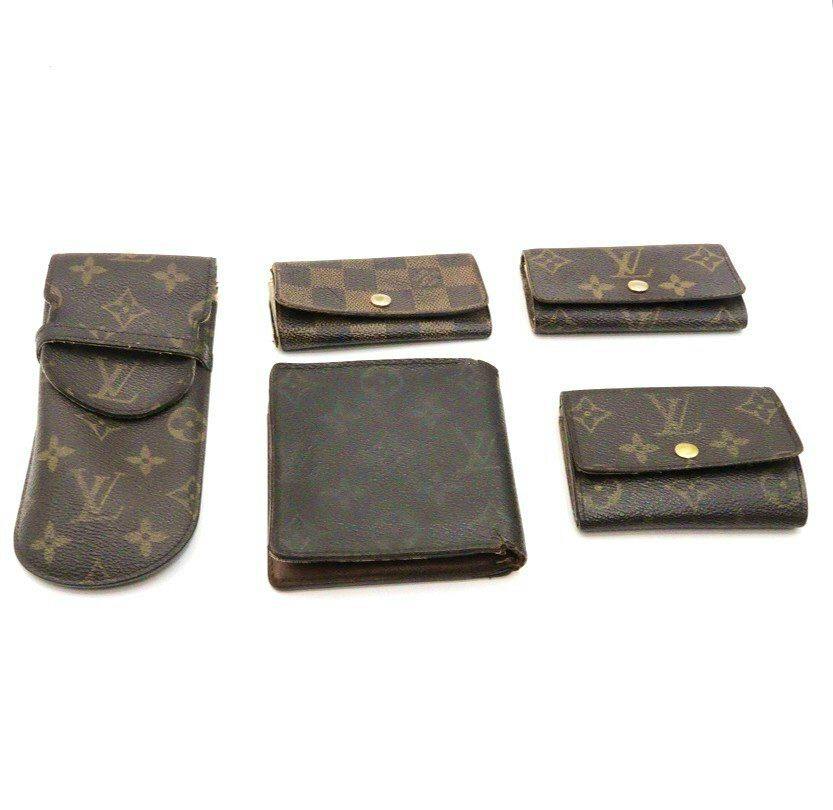 Five Louis Vuitton wallets and key cases arranged on a white background.