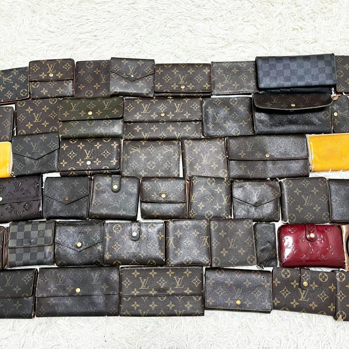 Multiple Louis Vuitton wallets and coin cases with monogram and Damier patterns arranged in rows on a white rug.