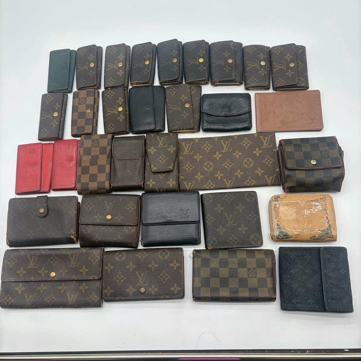 Assorted Louis Vuitton wallets and key cases arranged on a white background.