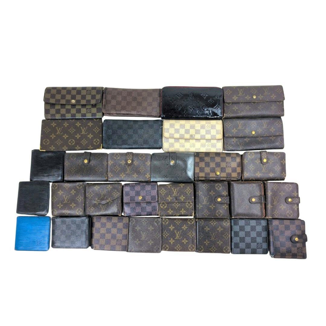 A collection of multiple Louis Vuitton wallets in monogram, Damier, and Epi leather patterns arranged in rows on a white background.