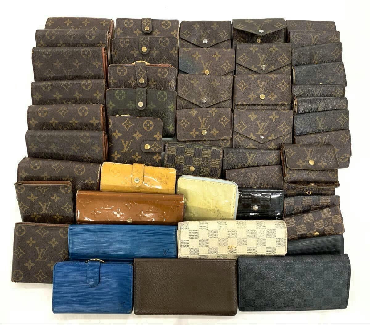 A large assortment of Louis Vuitton wallets in monogram, Damier, and Epi patterns arranged in rows on a white background.