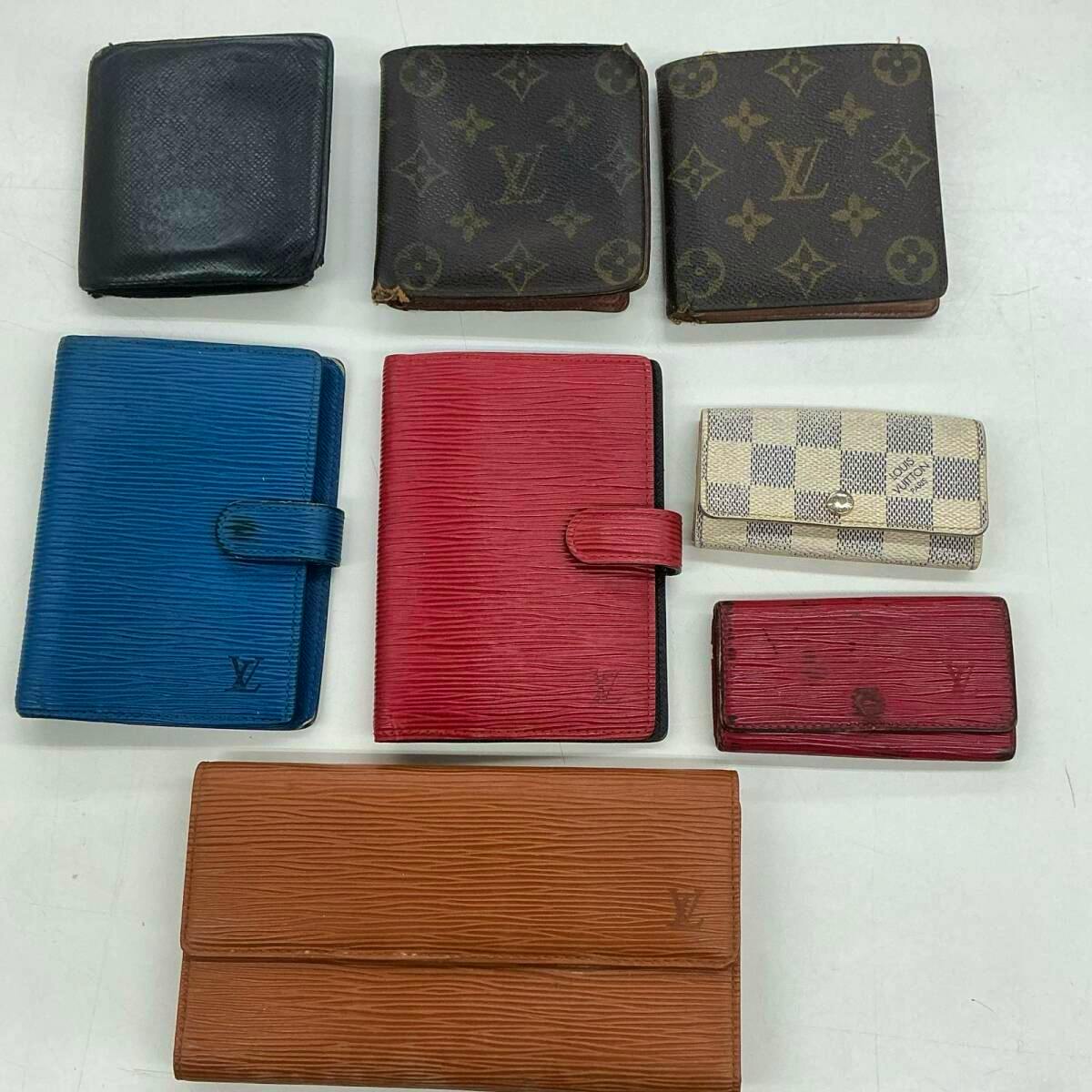 Eight Louis Vuitton wallets in various colors and patterns arranged on a white surface.