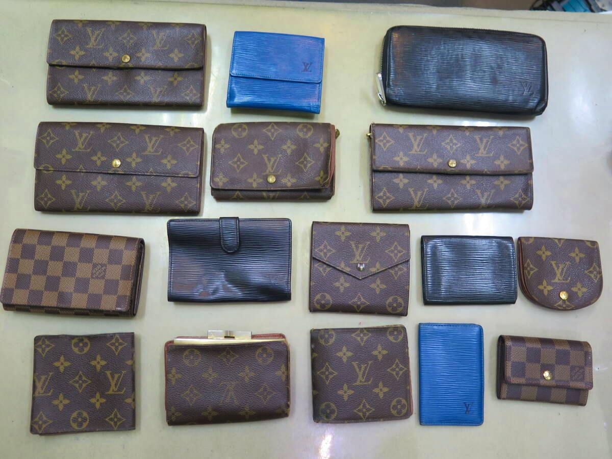 Multiple Louis Vuitton wallets and small leather goods arranged flat, showing monogram and checkered patterns.