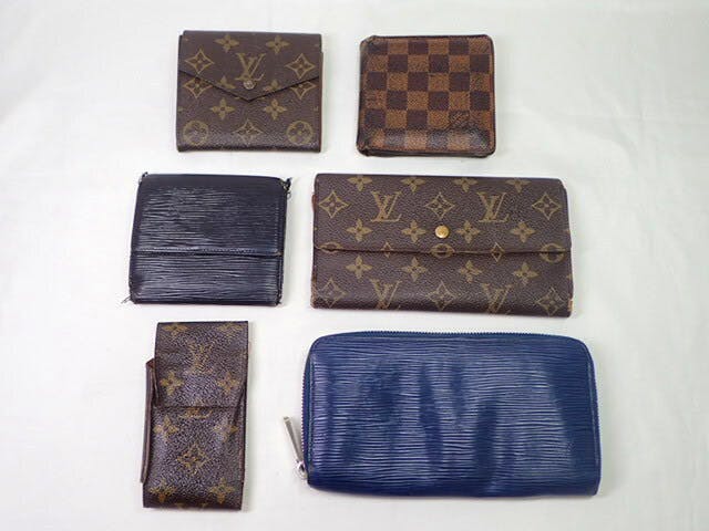 Six Louis Vuitton wallets and cases in Monogram, Damier, and Epi patterns arranged on a white background.