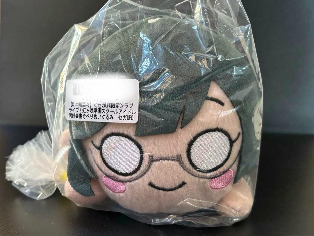 Packaged front view of the ラブライブ 虹ヶ咲 寝そべり 中川菜々 (優木せつ菜) plush showing its face and glasses.