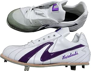 Low-cut white leather baseball spikes with purple side markings and metal studs visible.
