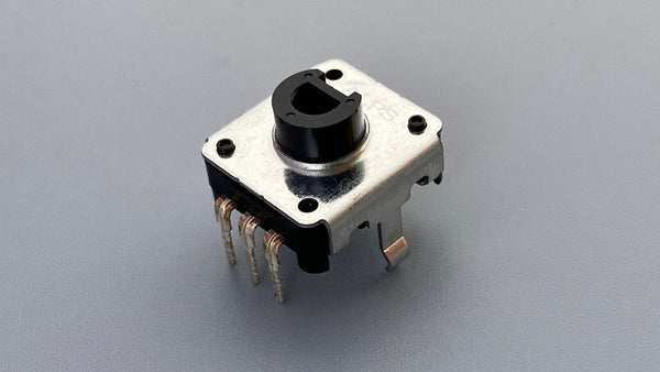 Low-profile rotary encoder switch on a gray background showing the black knob, metal housing, and multiple pins.