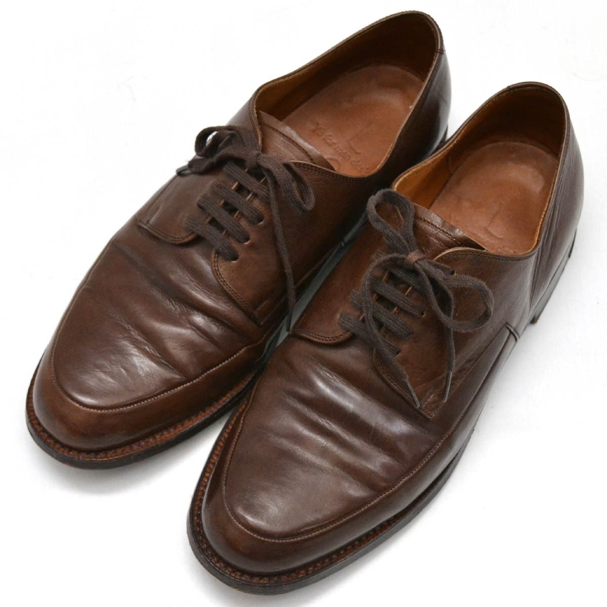 Top-down photo of a pair of brown leather men's lace-up shoes.