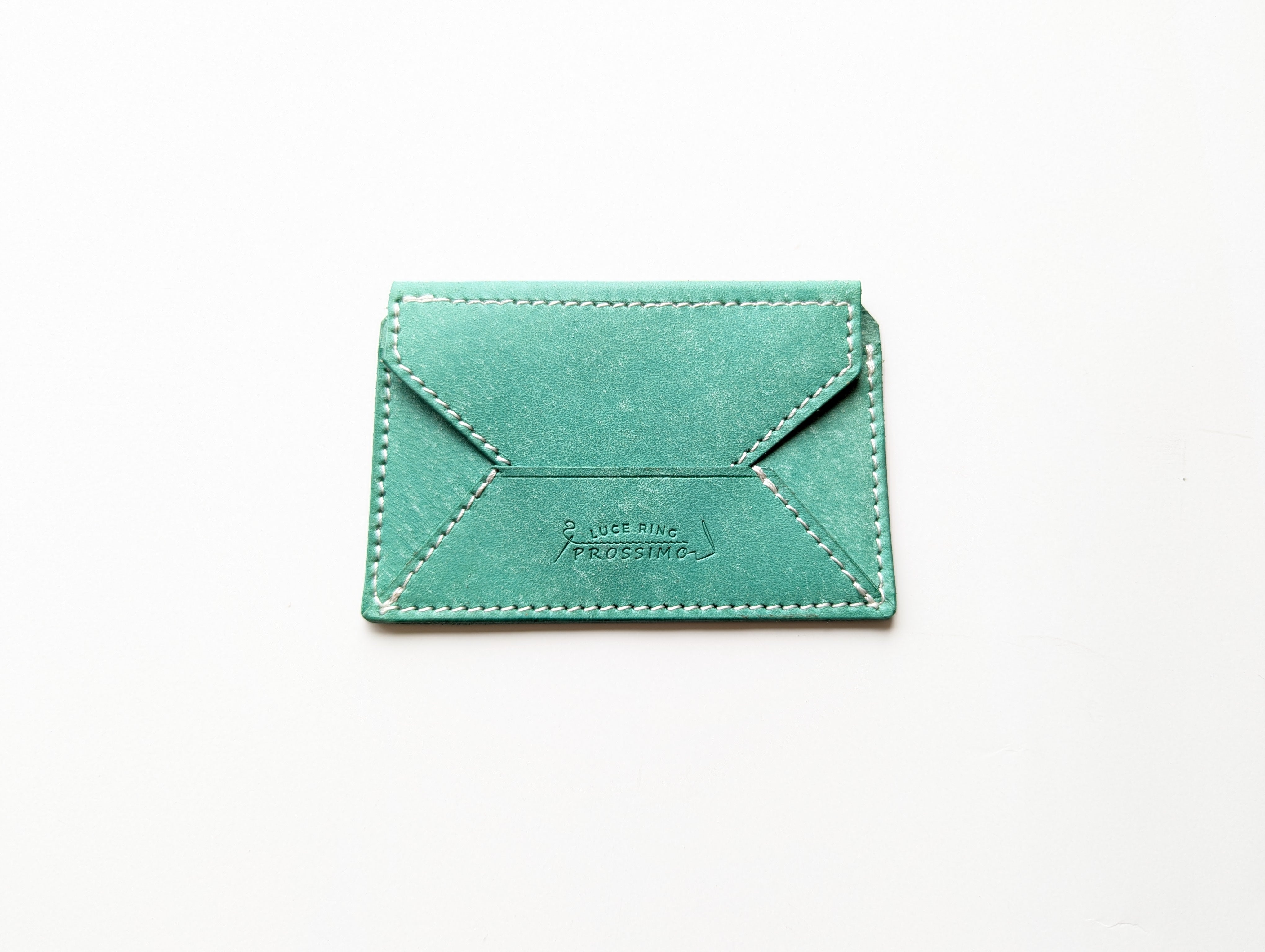Green cow leather LUCE card case with visible stitching and embossed logo on a white background.