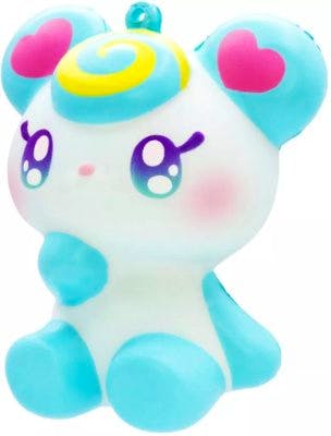 Front view of the 'Luna' squishy plush toy: a white and light-blue sitting character with a yellow-and-blue swirl on its forehead, heart shapes on its ears, rosy cheeks, and large cartoon eyes.