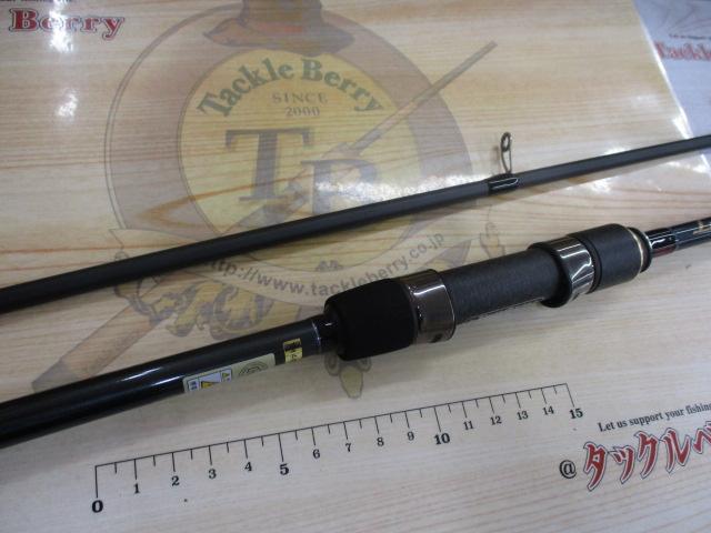 Fishing rod showing the handle, reel seat, and rod sections laid on a branded backdrop with a measuring ruler.