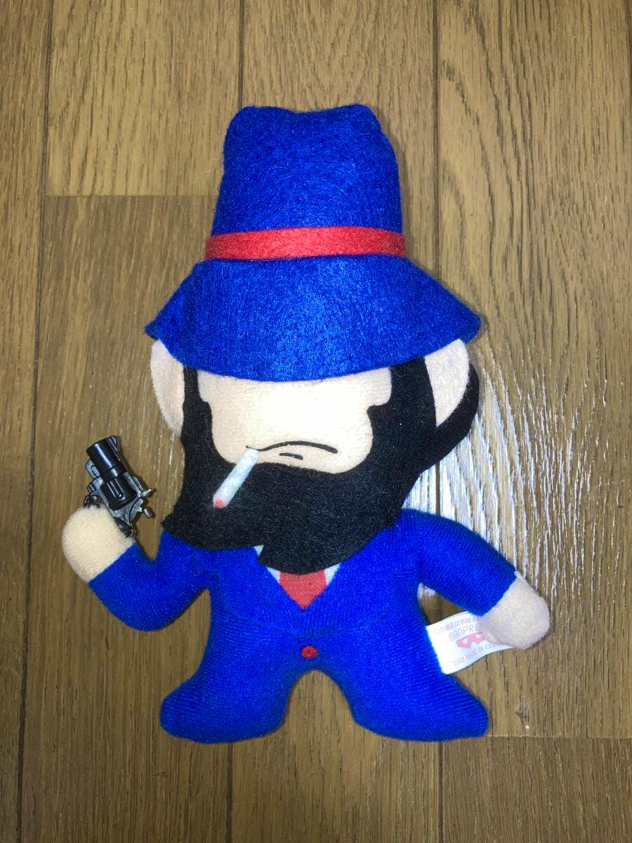 Front view of the Lupin III "Jigen" plush wearing a blue suit and hat, holding a small toy gun and with a cigarette visible.