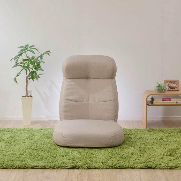 Front view of the beige reclining chair placed on a green rug against a white wall.