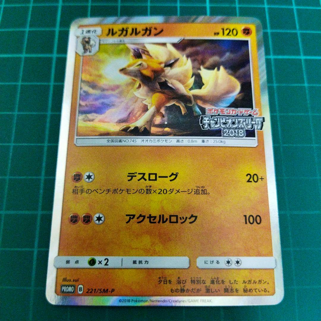 Front of the trading card showing the title "ルガルガン", the illustrated Pokémon artwork, Japanese text, and the promo code "221/SM-P" on a green grid mat.