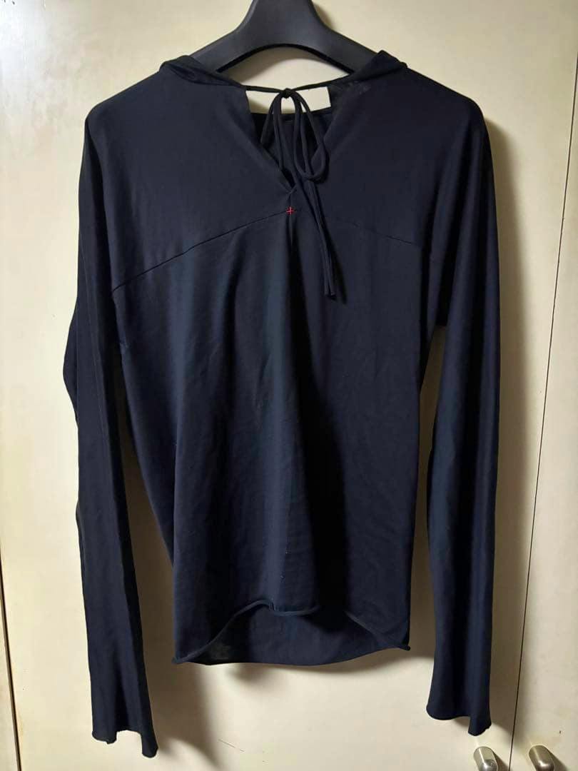 Front view of a black cotton long-sleeve sweatshirt with a hood and tie detail at the neckline hanging on a hanger.