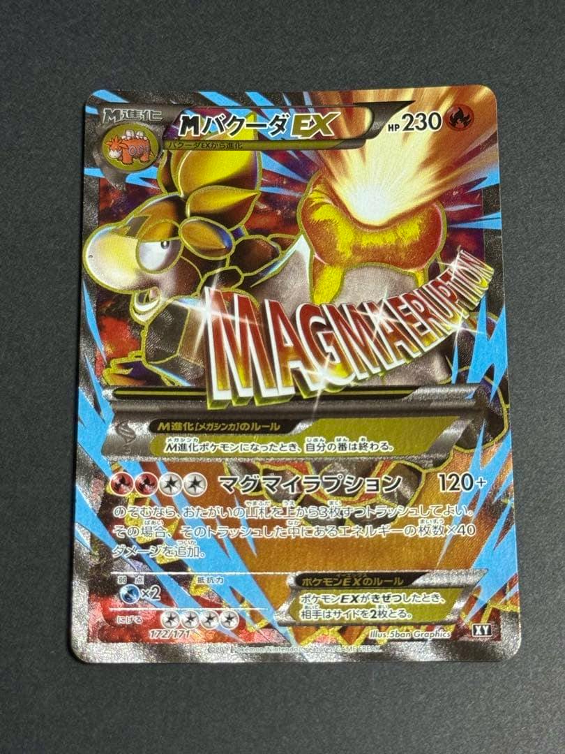 Photo of the MバクーダEX SR trading card (THE BEST OF XY) front showing the holographic card artwork and Japanese text.