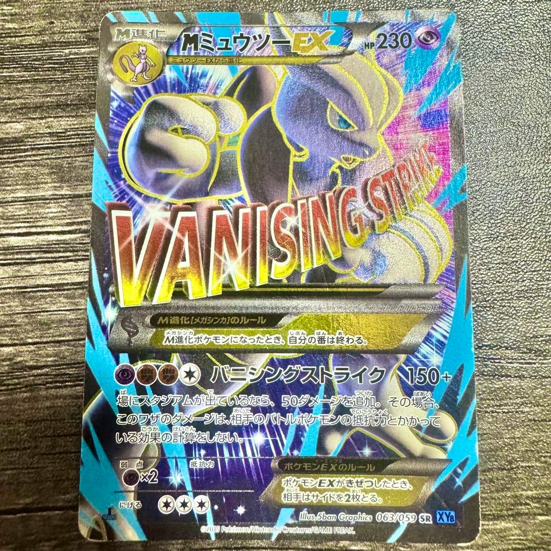 Front holographic Pokémon trading card (Japanese) showing MミュウツーEX with large "VANISHING STRIKE" art and attack/HP text.