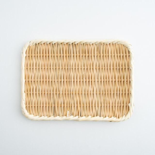 Top-down view of a rectangular woven bamboo strainer/tray showing its woven pattern and wrapped rim.