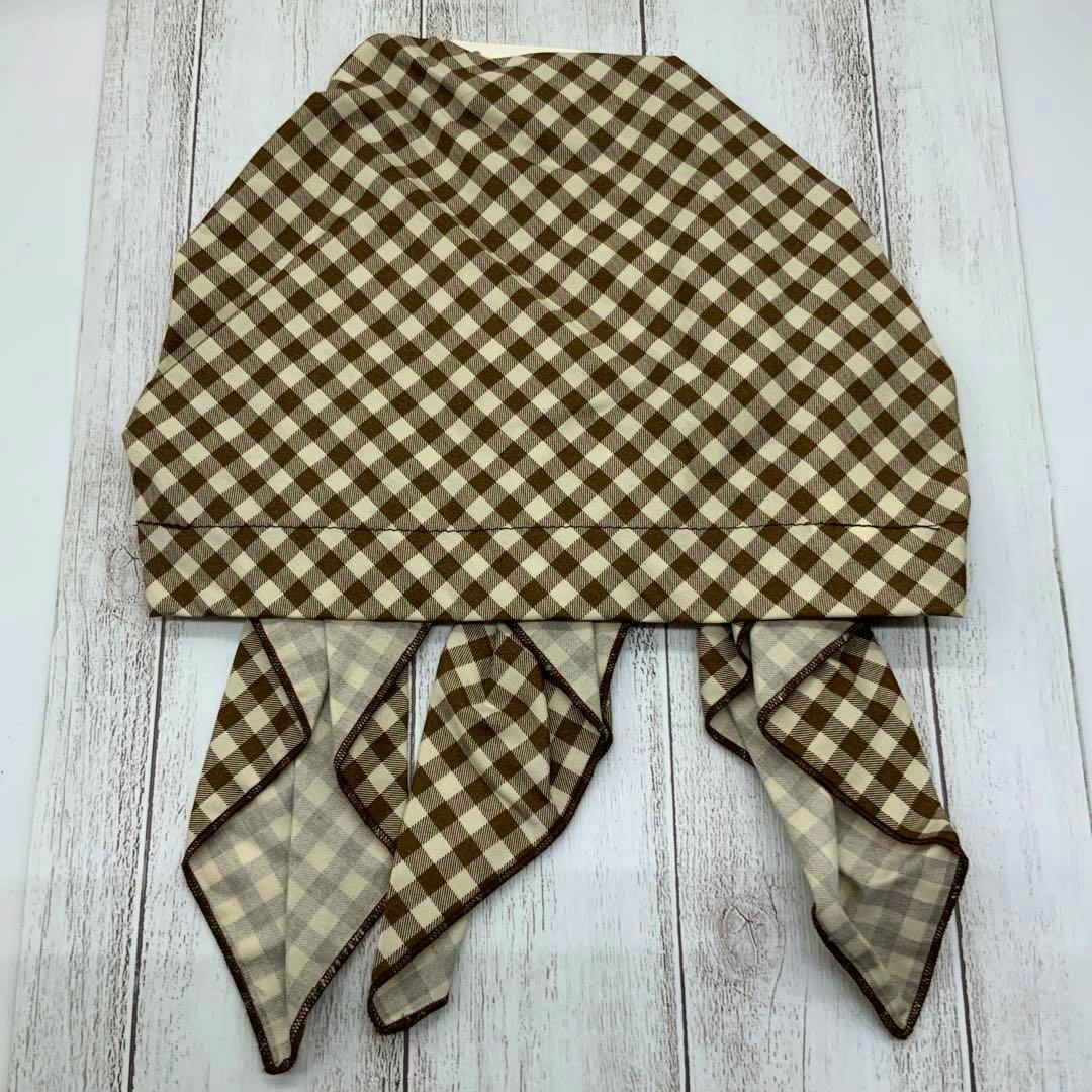 Brown and cream checked cotton bandana cap laid flat showing the front panel and attached tails.