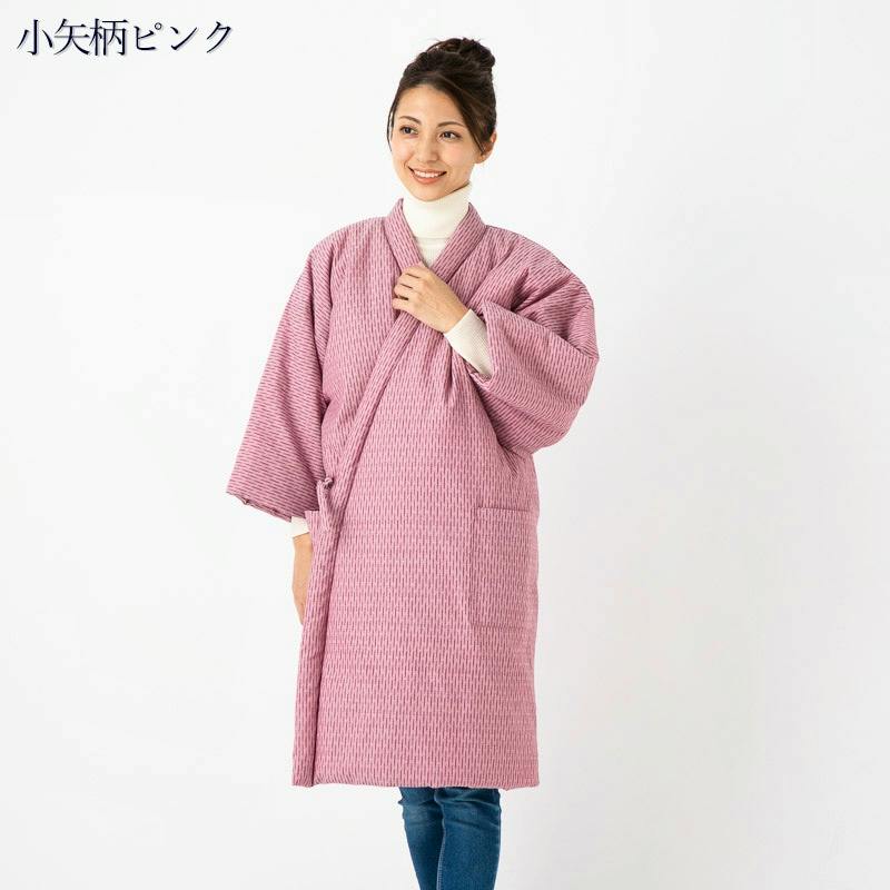 Woman modeling a long pink cotton hanten-style women's jacket with a front overlap and side pocket.