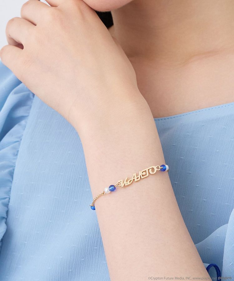 A model's wrist wearing the KAITO image 2way bracelet with blue beads and a horizontal decorative plate.