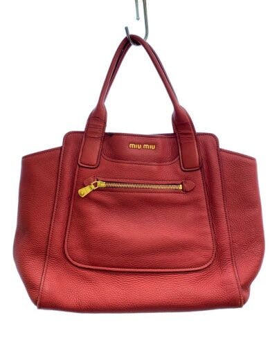 Red textured leather tote bag shown from the front with dual handles and a front zip pocket.