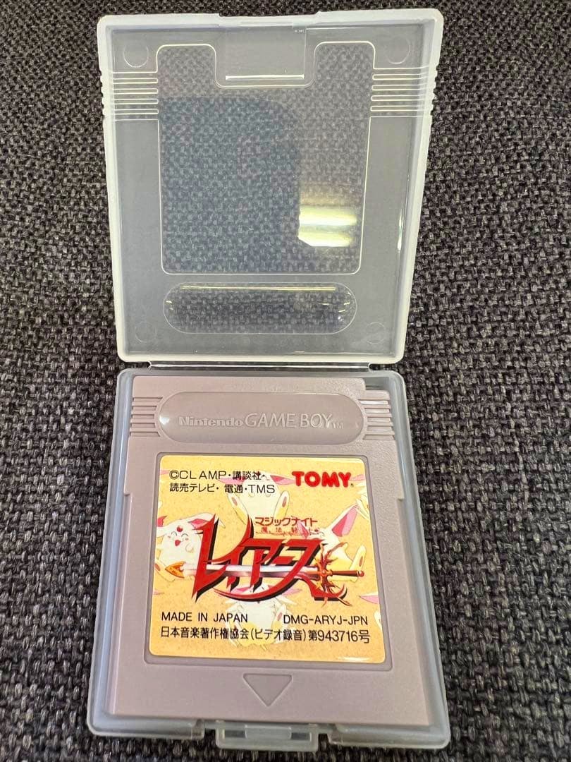 A Game Boy cartridge for "Magic Knight Rayearth" inside a clear plastic case on a dark textured surface.