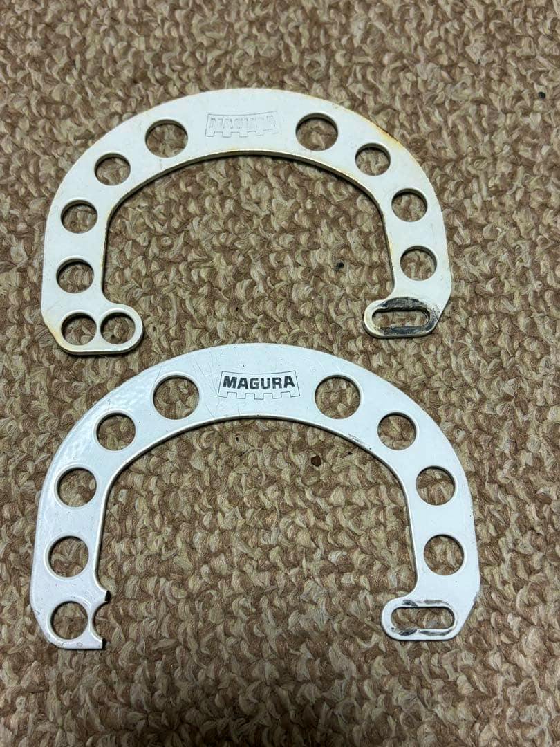 Two white MAGURA HS33 brake booster plates shown on a carpeted background.