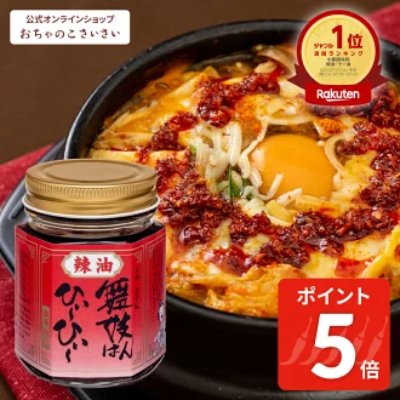 A jar of the "舞妓はんひぃ～ひぃ～" chili oil rice seasoning shown next to a cooked egg-topped dish.
