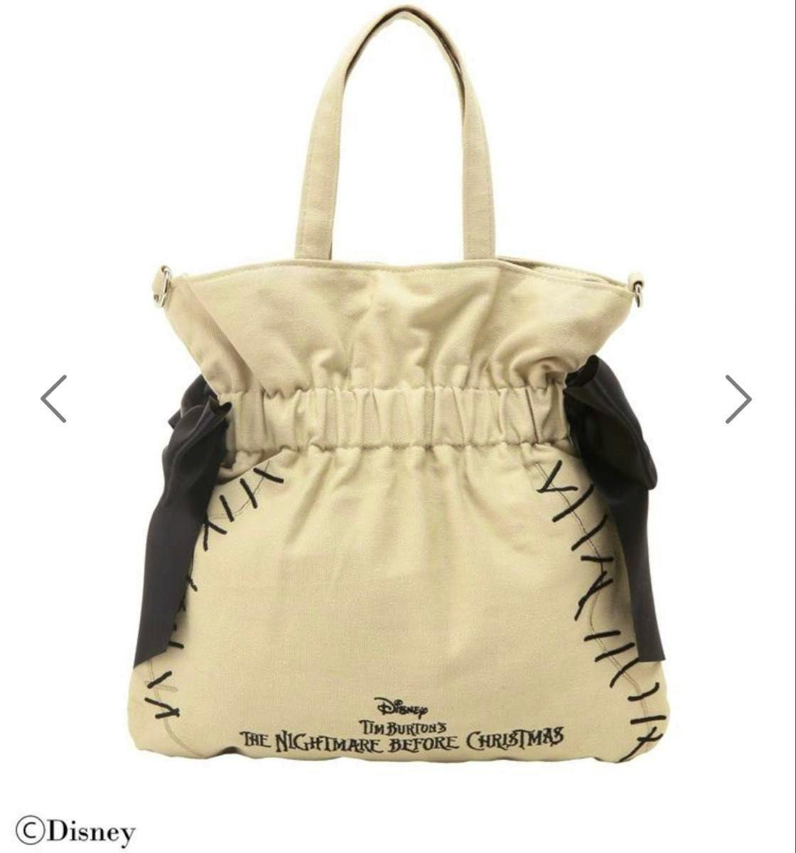 Beige tote bag with a gathered top, black side ribbons, and "The Nightmare Before Christmas" printed near the bottom.