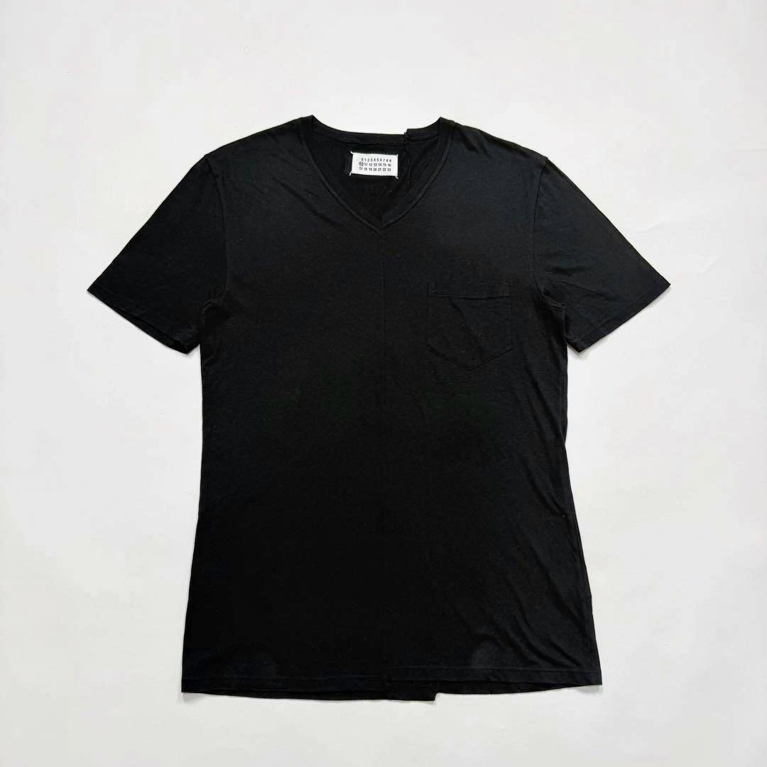 Front flat-lay of the Martin Margiela asymmetry design black cotton T-shirt showing a V-neck and chest pocket on a white background.